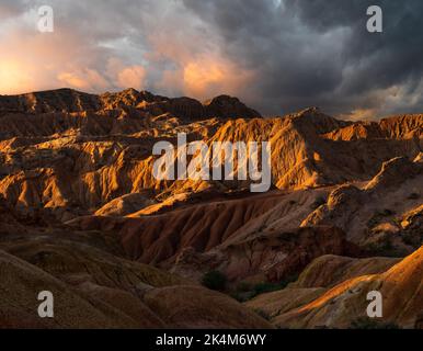 Dramatischer Sonnenuntergang am farbenfrohen Skazka Fairyale Canyon in Issyk-Kul Region, Kirgisistan Stockfoto