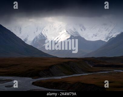 Dramatisches Morgenlicht auf schneebedeckten Gipfeln der Tien Shan-Bergkette in Kirgisistan Stockfoto