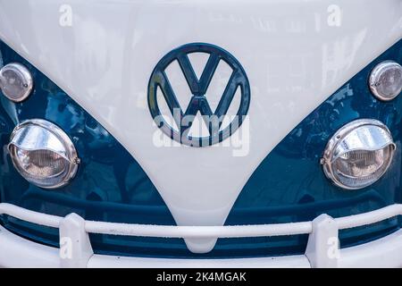 Vorderlichter und VW-Emblem eines klassischen Volks Wagen Wohnwagens in blau und weiß Stockfoto