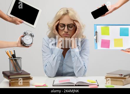 Müde junge Geschäftsfrau sitzt am Schreibtisch, Zeitmanagement-Konzept Stockfoto