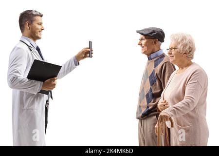 Junger Arzt, der älteren Patienten ein Mobiltelefon zeigt, das auf weißem Hintergrund isoliert ist Stockfoto
