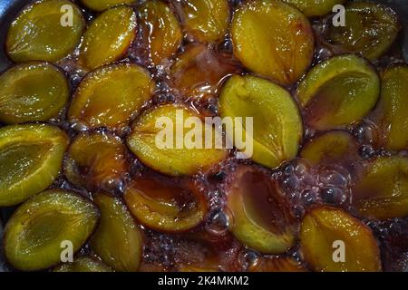 Reife Pflaumen werden in Zuckersirup gekocht Stockfoto