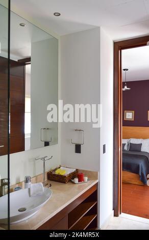 Geräumiges Bad in Grautönen mit Fußbodenheizung, freistehender Badewanne und begehbarer Dusche. Stockfoto