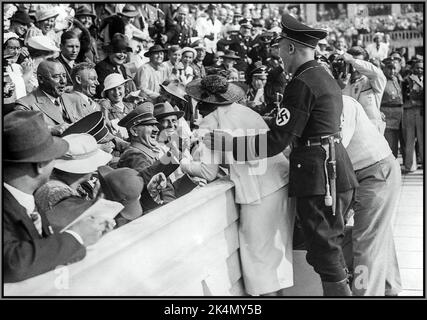 BERLINER OLYMPISCHE SPIELE HITLER Adolf Hitler lacht und reagiert auf einen Kuss einer begeisterten amerikanischen Fan bei den Olympischen Spielen in Berlin 1936. Stockfoto