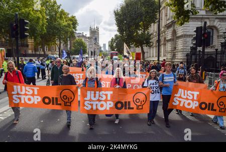 London, Großbritannien. 03. Oktober 2022. Demonstranten marschieren während der Demonstration mit „Just Stop Oil“-Transparenten in Whitehall. Der Protest war Teil einer Reihe von Demonstrationen, die täglich in Westminster stattfanden, wobei die Klimaschutzgruppe ein Ende der fossilen Brennstoffe und einen Wechsel zu erneuerbaren Energien forderte. Kredit: SOPA Images Limited/Alamy Live Nachrichten Stockfoto