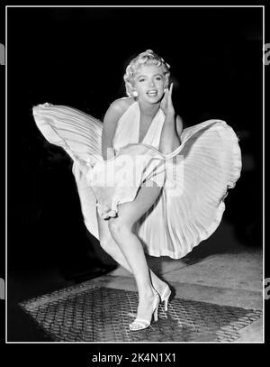 Der Rock von Marilyn Monroe wird in die Luft gesprengen, um das 7 Year Itch Vintage Film Retro-Bild 1950s zu bewerben, während der Film „The Seven Year Itch“ auf den Straßen von New York gedreht wurde, Sie blieb offenbar während der Dreharbeiten zur berühmten „Rock-Szene“ stehen und posierte für die Reporter und Fotografen, die den Film filmten. Das Ergebnis ist ein ikonisches Bild, das den Film sofort hervorgebracht hat. Datum: 9. September 1954 Stockfoto