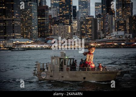 Die kleine Amal, eine 12 Meter hohe riesige Marionette, die einen 10-jährigen syrischen Flüchtling darstellt, segelt am letzten Tag ihres Besuchs in New York City auf einem Boot. Stockfoto