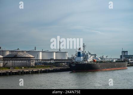 Rotterdam, Niederlande - 11. Juli 2022: Kriti Rock Öltanker am Kai vor Öl- und Gasspeichertanks unter dem verdichtenden Abendhimmel. Shell-Refine Stockfoto