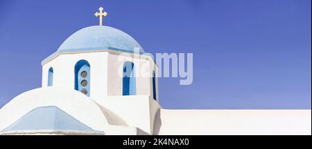 Griechische Insel traditionelles Tempelkonzept. Oben auf der orthodoxen Kirche mit blauer Kuppel weiß getünchten Gebäude und überqueren gegen klaren blauen Himmel, sonnigen Tag. Platz Stockfoto