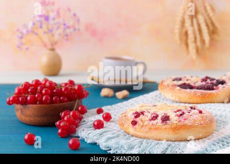 Nahaufnahme von Kuchen mit Sommerfrüchten, Johannisbeeren, Pflaumen, Brombeeren, Blaubeeren und Krümel, Blauer Holztisch, niedriger Blickwinkel, keine Menschen. Stockfoto