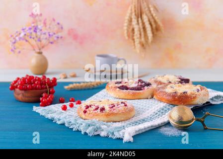 Gebackene Kuchen mit Sommerfrüchten, Johannisbeeren, Pflaumen, Brombeeren, Blaubeeren und Krümel, Blauer Holztisch, niedriger Blickwinkel, keine Menschen. Stockfoto