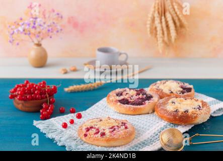 Gebackene Kuchen mit Sommerfrüchten, Johannisbeeren, Pflaumen, Brombeeren, Blaubeeren und Krümel, Blauer Holztisch, niedriger Blickwinkel, keine Menschen. Stockfoto