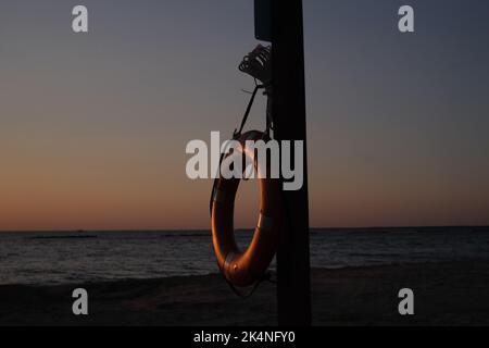 Dies ist ein lebensrettendes Gerät, um Ertrinken zu verhindern. Diese Rettungsweste hängt an einem Holzpfosten am Cypremort Point Beach in der Nähe der Golfküste von Stockfoto