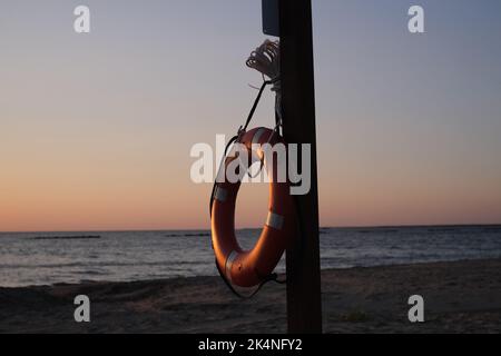 Dies ist ein lebensrettendes Gerät, um Ertrinken zu verhindern. Diese Rettungsweste hängt an einem Holzpfosten am Cypremort Point Beach in der Nähe der Golfküste von Stockfoto