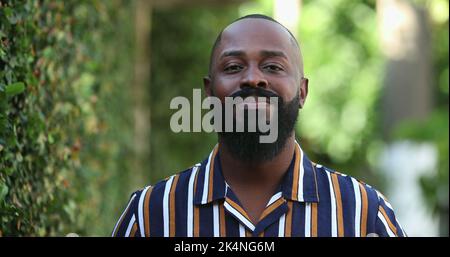 Positiver glücklicher afrikanischer Mann, der draußen lächelt und frische Luft atmet Stockfoto