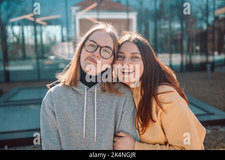 Zwei junge lächelnde Hipster-Frauen, die Selfie-Selbstporträts auf dem Smartphone machen und positive Emotionen zeigen Stockfoto