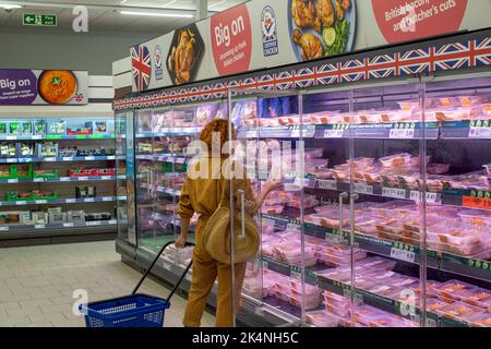 London, Großbritannien. September 29 2022. Eine Frau, die den Fleischpreis auf einem Kühlregal im Lidl-Laden in Lewisham, London, England, überprüft Stockfoto