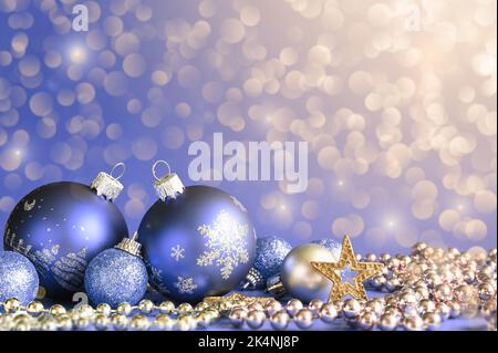 Pinke Weihnachtskugeln auf silbernem Glitzer mit defokusem Licht auf dem Hintergrund, Neujahrskarte. Klassischer Blauton. Stockfoto