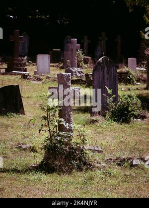 Ein raues, gehautes Kreuz im Friedhof Stockfoto
