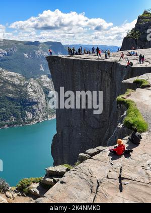 Touristen, die den Gipfel des Preikestolen oder den "Pulpit Rock" besuchen, eine beliebte steile Klippe über dem Lysefjord in Norwegen. Stockfoto