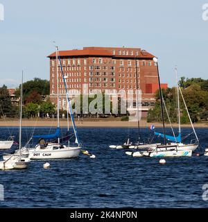 Die Marina des Minneapolis, Minnesota Sailing Center am Lake BDE Maka Ska mit den 1928 Beach Club Residences im Hintergrund. Stockfoto