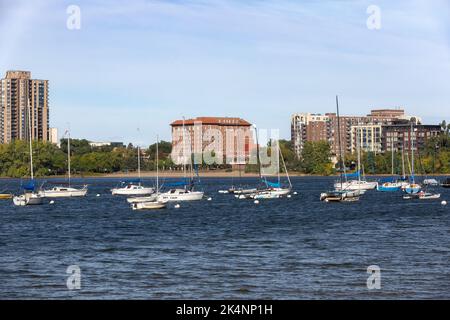 Segelboote am Yachthafen des Minneapolis Sailing Center am Lake BDE Maka Ska, Minnesota. Im Hintergrund befindet sich das 1928 Beach Club Residences Gebäude. Stockfoto