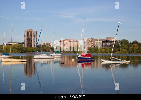 Segelboote am Yachthafen des Minneapolis Sailing Center am Lake BDE Maka Ska, Minnesota. Im Hintergrund befindet sich das 1928 Beach Club Residences Gebäude. Stockfoto