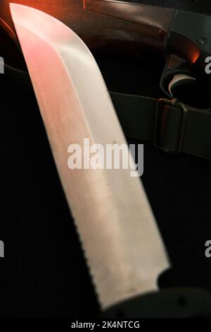 Waffe auf schwarzem Tuch: Messer, Gewehr, Draufsicht. Draufsicht auf Messer, Gewehr. Stockfoto