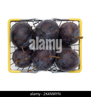 Kleiner Einkaufskorb mit Früchten, Äpfeln, reifen Pflaumen im Korb isoliert auf weißem Hintergrund, Draufsicht, Lebensmittelmarkt Bäckereikonzept Stockfoto