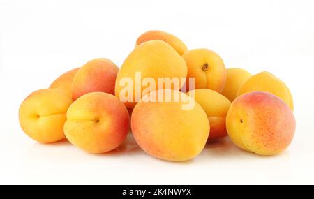 Haufen von ganzen Aprikosen isoliert auf weißem Hintergrund.reife süße Früchte Stockfoto