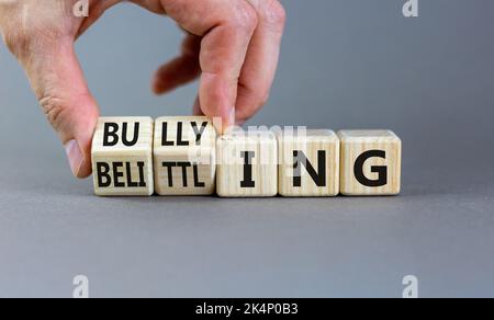 Mobbing und herabsetzenden Symbol. Konzeptworte Mobbing und Herabsetzung auf Holzwürfeln. Geschäftsmann Hand. Schöne graue Tabelle grauen Hintergrund. Unternehmen Stockfoto