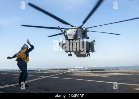 Ryan Akerson, ein Bootsmann auf der U.S.N.S Sacagawea, leitet einen CH-53E Super Hengst auf ein Landedeck im Kushiro Port, Japan, 1. Oktober 2022. Das United States Naval Ship Sacagawea dient als Kommandooperationszentrum für das Combat Logistics Regiment 37 und bietet logistische Unterstützung für verschiedene Einheiten, die an Resolute Dragon teilnehmen. Resolute Dragon 22 ist eine jährliche Übung zur Stärkung der Verteidigungsfähigkeit der US-japanischen Allianz durch integrierte Kommando- und Kontrollmaßnahmen, Zielführung, kombinierte Waffen und Manöver über mehrere Domänen hinweg. (USA Marine Corps Foto von L Stockfoto