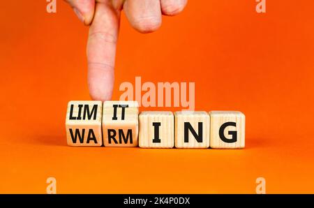 Symbol für Begrenzung der globalen Erwärmung. Konzept Worte Begrenzung und Erwärmung auf Holzwürfel. Geschäftsmann Hand. Schöne orange Tisch orange Hintergrund. Bus Stockfoto