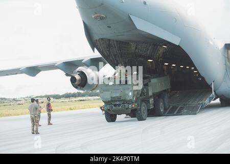 Ein US-Armeesoldat, der Bravo Battery, 1. Bataillon, 94. Field Artillery Regiment, 17. Field Artillery Brigade aus der Joint Base Lewis-McChord, Wash., zugewiesen wurde, steht hoch in der Luke eines Hight Mobility Artillery Rocket System Fahrzeugs und leitet den Fahrer vom Asphalt auf der Andersen Air Force Base, Guam, 26. September 2022. Die HIMARS nahmen an einer Trainingsveranstaltung mit Soldaten Teil, die 2. Bataillon, 27. Infanterie-Regiment, 3. Infanterie-Brigade-Kampfteam, 25. Infanterie-Division zugewiesen wurden. Stockfoto