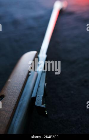 Luftgewehr für die Jagd auf Stoff dunklen Hintergrund. Stockfoto