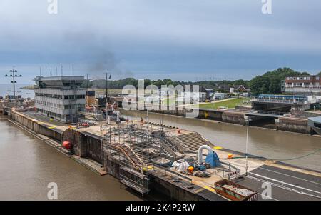 Brunsbuttel, Deutschland - 12. Juli 2022: Kieler Kanal-Schleuse. Kontrollzentrum Gebäude am Kai zwischen 2 Schleusen unter blauem Himmel. Andere Gebäude und gre Stockfoto