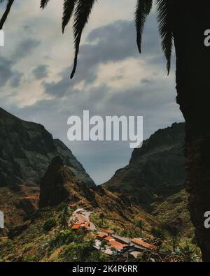 Eine vertikale Aufnahme von malerischen Bergen und einem Dorf an einem bewölkten Tag im Masca Canyon, Teneriffa, Kanarische Inseln, Spanien Stockfoto
