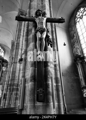 Eine Graustufenaufnahme einer Skulptur von Jesus Christus am Kreuz in einer Kirche Stockfoto