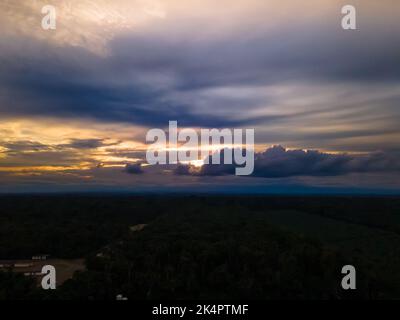 Blick über den Sonnenuntergang über dem Amazonas-Fluss mit Regenwald in Ecuador Stockfoto