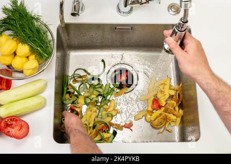 Funktionierende Küchendisponiereinrichtung auf einem modernen Waschbecken, um Lebensmittelabfälle zu entfernen Stockfoto