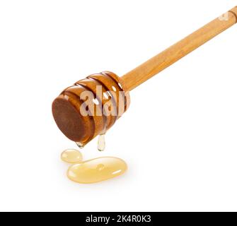 Honig und Holzhonig Dipper auf weißem Hintergrund. Honig tropft aus dem Honigtauchmittel. Nahaufnahme. Stockfoto