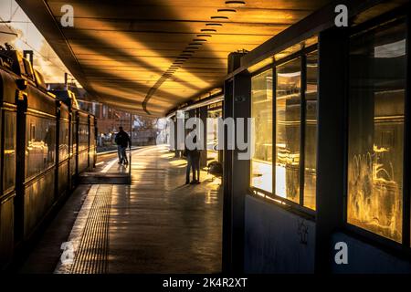 Ein Paar, das sich am Abend küsst, leuchtet auf einem Bahnsteig in Lissabon, Portugal Stockfoto