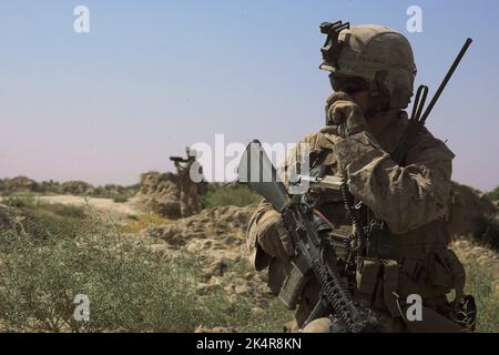 PROVINZ HELMAND, AFGHANISTAN - 27. Juli 2009 - das US Marine Corps Lance CPL Scott Nechay nutzt während einer Sicherheitssatrouille in der Provinz Helmand ein Funkgerät Stockfoto