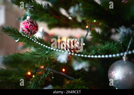 Dekoration des Weihnachtsbaums für Feiertage, Zapfen, Kugeln, Girlanden, Perlen. Vorderansicht. Stockfoto