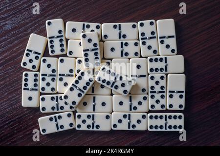Auf dem Holztisch verstreute Dominosteine Stockfoto