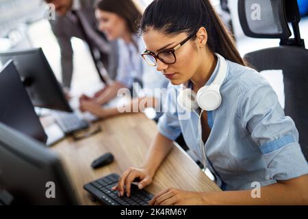Lächelnde, freundliche Callcenter-Agent mit Headset, die im Büro an der Support-Hotline arbeitet Stockfoto