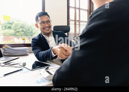 Geschäftsmann Handshake für Teamarbeit der Unternehmensfusion und -Übernahme, erfolgreiche Verhandlungen, zwei Geschäftsmann schütteln Hand mit Partner zu feiern Stockfoto