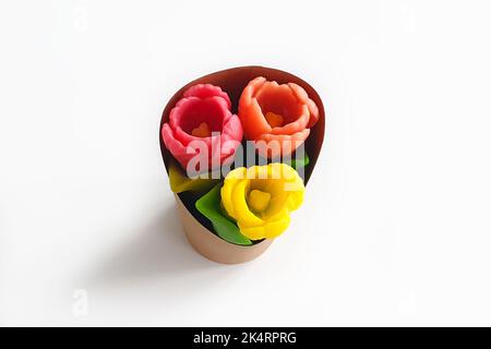 Pinkfarbene, rote und gelbe Tulpen aus Seife in Geschenkbox isoliert auf weißem Hintergrund. Draufsicht, Kopierbereich. Stockfoto