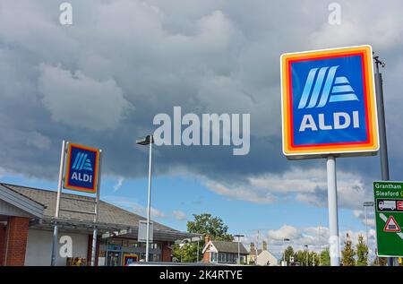 ALDI-Geschäft auf dem Dach und Schilder mit stürmischem Himmel im Hintergrund in Boston Lincolnshire Stockfoto