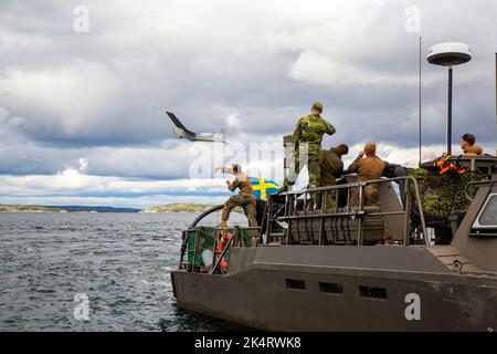 Burga, Schweden. 15. September 2022. U.S. Marines with Mobile Reconnaissance Company, 2D Light Armored Reconnaissance Bataillon, and Swedish Marines, with 202d Coastal Ranger company, 2D Swedish Marine Bataillon, setzt ein unbemanntes RQ-20 Puma-Luftfahrtsystem von einem schwedischen Kampfboot 90 ein, um mithilfe eines SIMRAD-Radarsystems ein Bedrohungsschiff positiv zu identifizieren (Oben rechts), während der Übung Archipelago Endeavour 2022 (AE22), auf dem Berga Naval Base, Schweden, 15. September 2022. AE22 ist eine integrierte Schulung vor Ort, die die operative Leistungsfähigkeit erhöht und die strategische Zusammenarbeit verbessert Stockfoto